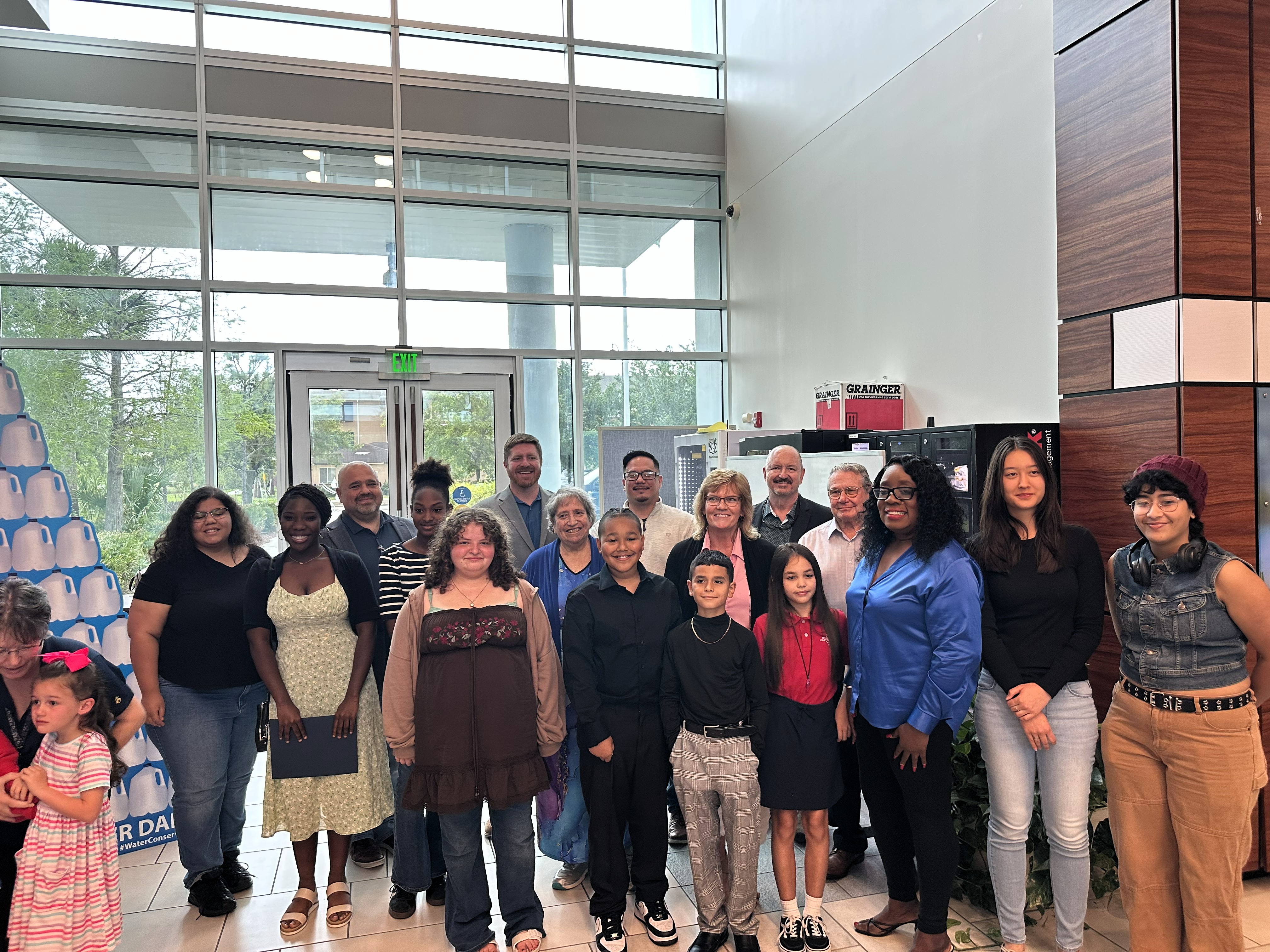 students gather with board members in a bright window lit atrium 