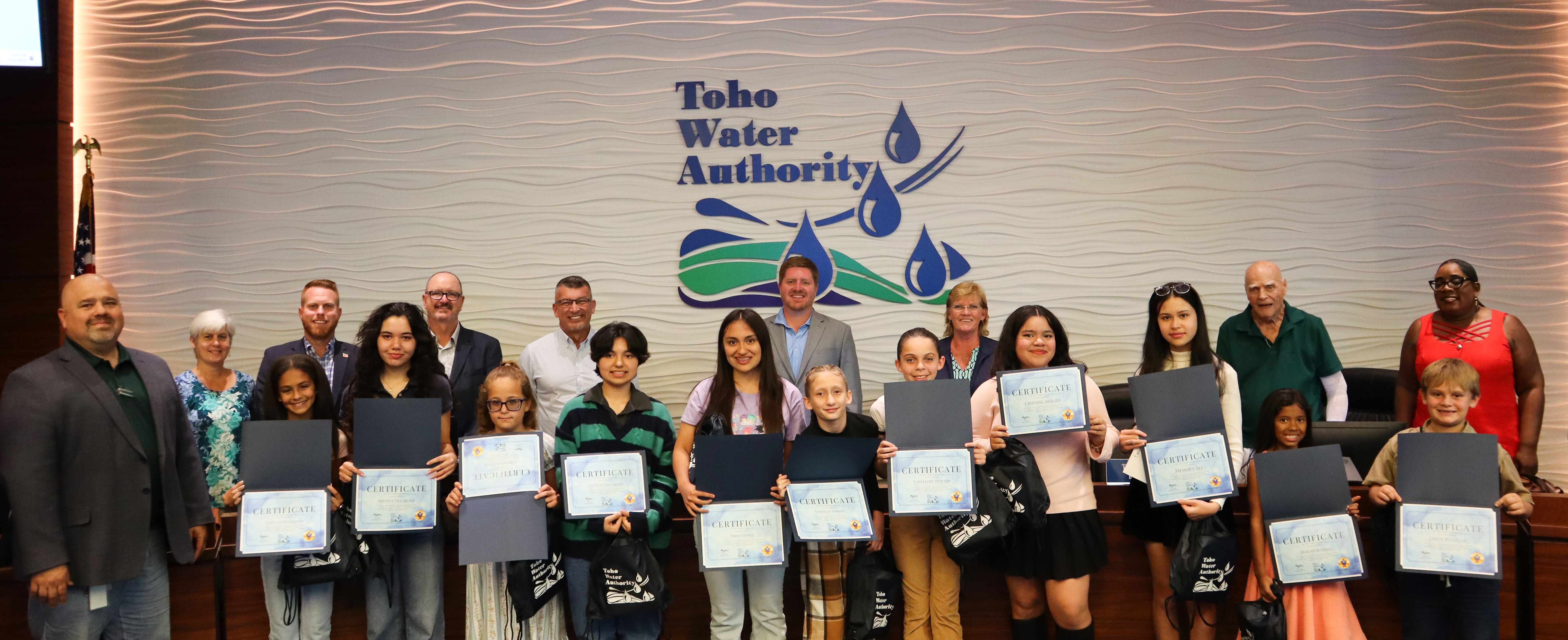 Toho Water Authority Chief Executive Officer Todd Swingle (L) stands with Toho’s Board of Supervisors to celebrate the winners of the 2025 Drop Savers Calendar Contest at the April 16, 2025, board meeting.
