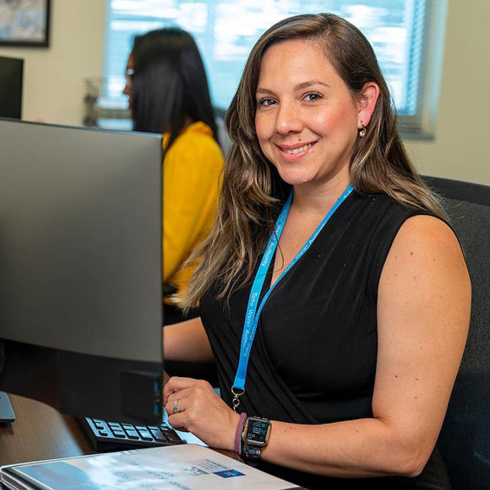 Image of female administrative assistant at her desk. 