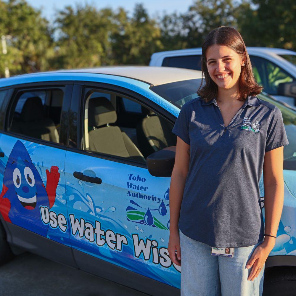 Image of water conservation specialist standing next to company vehicle.