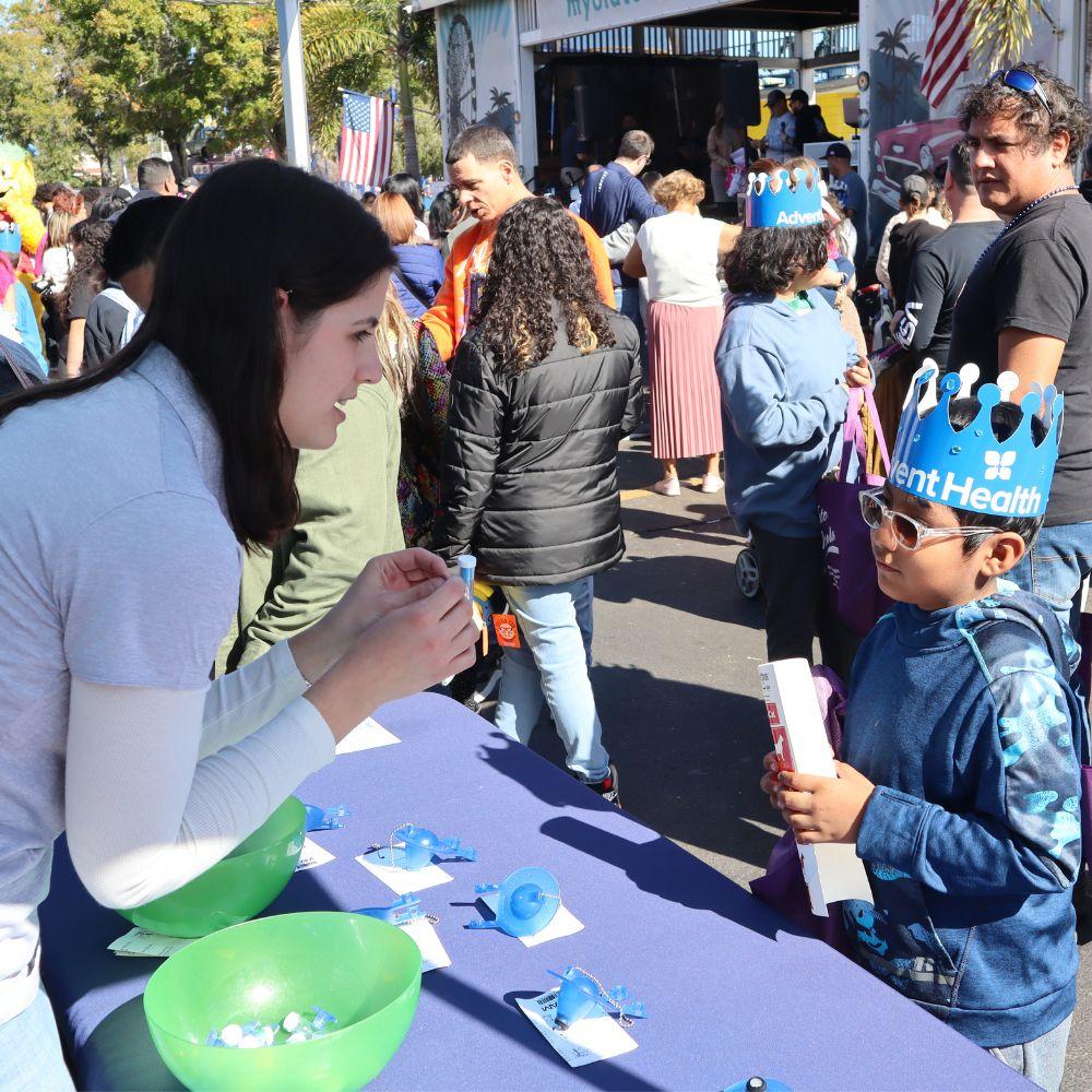 Image of Conservation Specialist talking to a young boy at event booth.