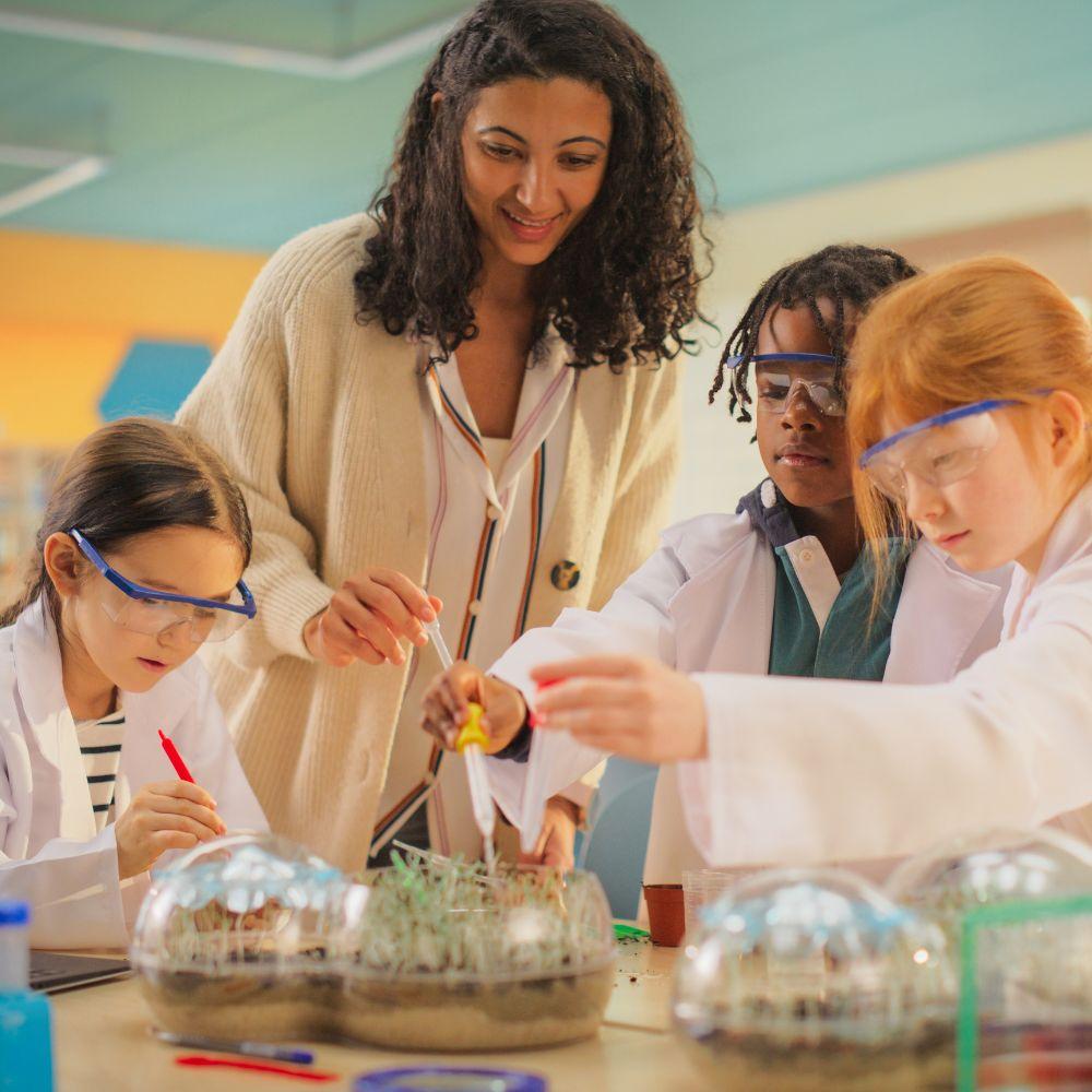 Image of science teacher with students conducting an experiment. 